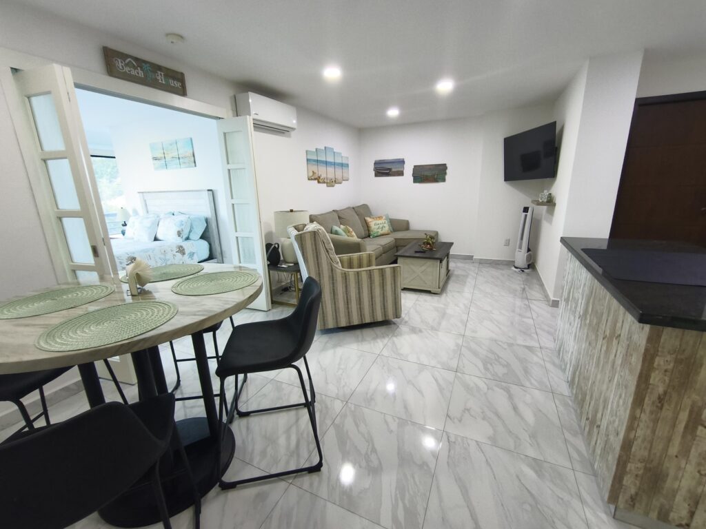 Los Cabos Morgan Residences Morgan Residences Condo 306 offers 67 m² of functional living space with one bedroom, one and a half baths, and a private balcony overlooking the city. The open floor plan connects the kitchen, dining, and living areas with marble-style tile throughout. The kitchen has granite counters, white cabinets, and an island with seating. The bedroom includes an ensuite bathroom with a walk-in shower and opens to the terrace. A separate half bath includes in-unit laundry. The building features a rooftop pool, gym, BBQ area, and – 1921 8 de Octubre, Cabo San Lucas, BS